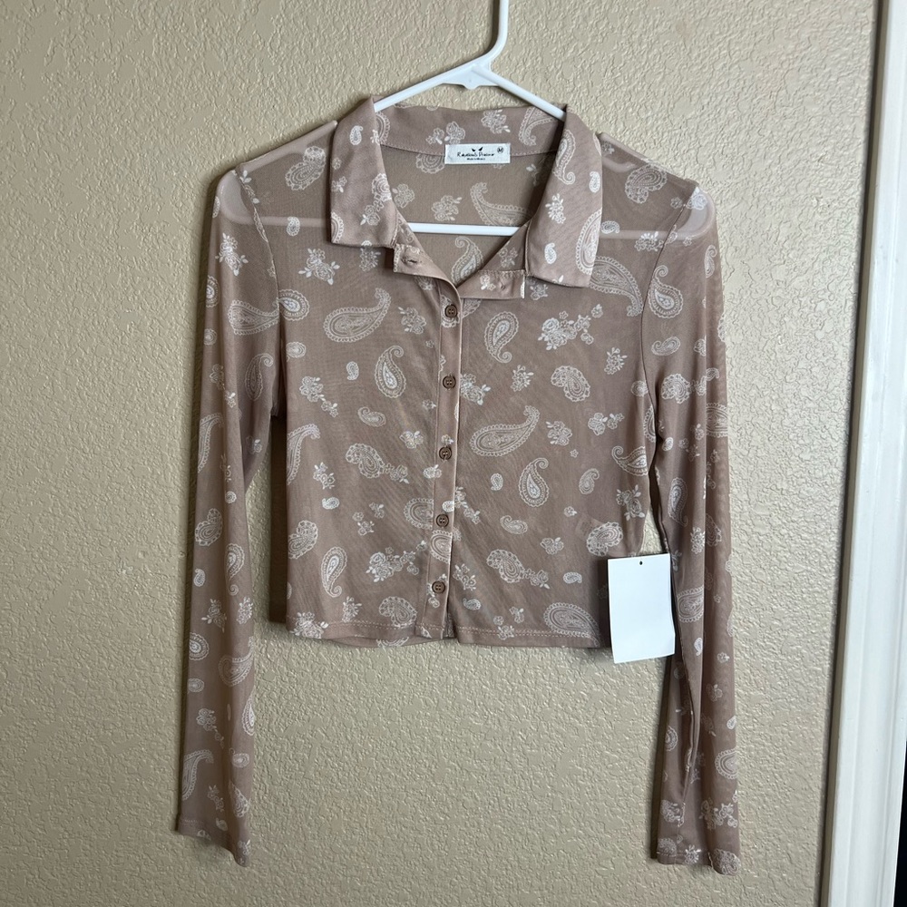 Long sleeve, crop top, buttons down the front. Fits small, and medium.
